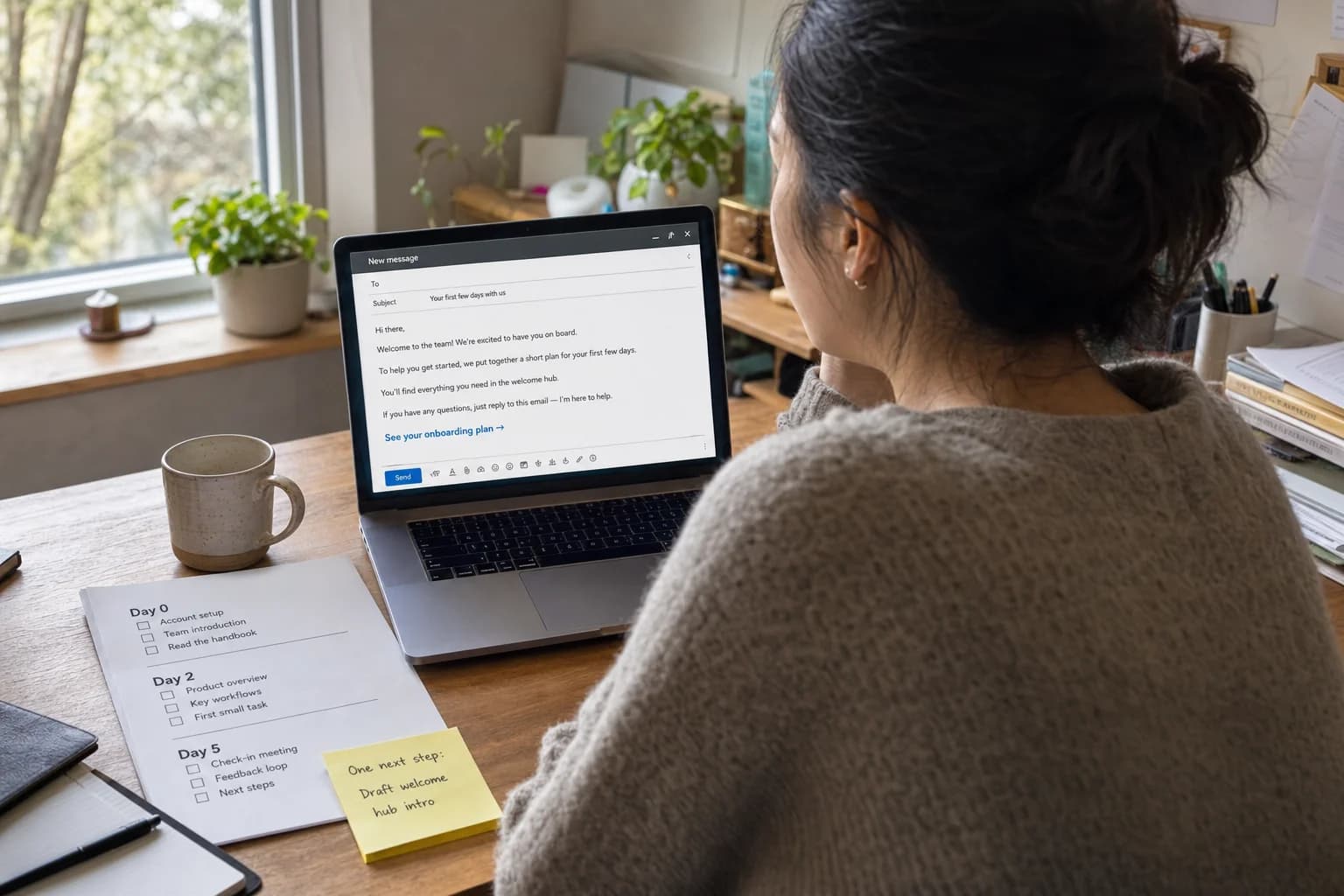 Solo founder at a home desk drafting an onboarding email on a laptop beside a printed Day 0, Day 2, and Day 5 checklist