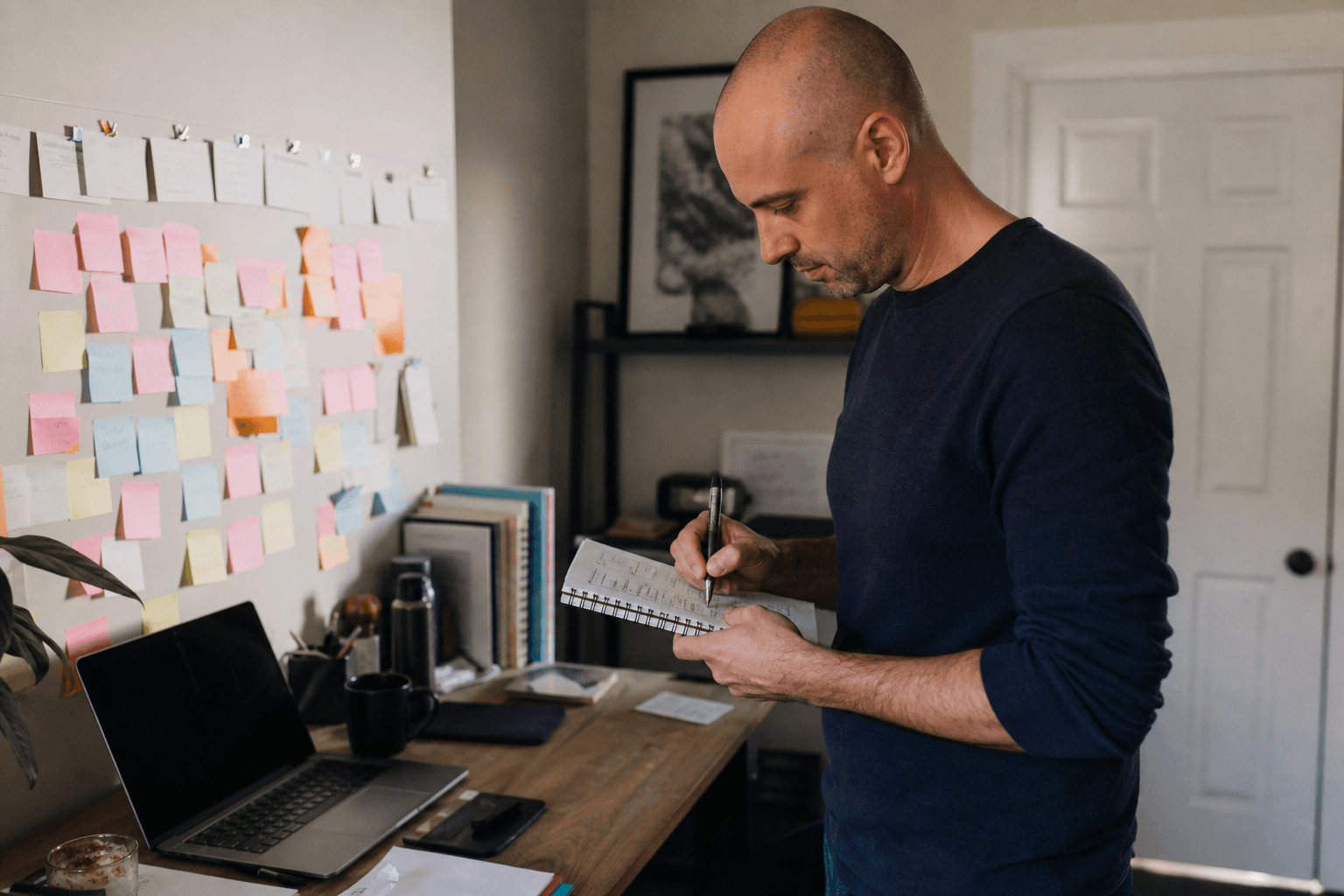 Founder sketching a one-page customer profile on a notepad with sticky notes marking communities where those people gather